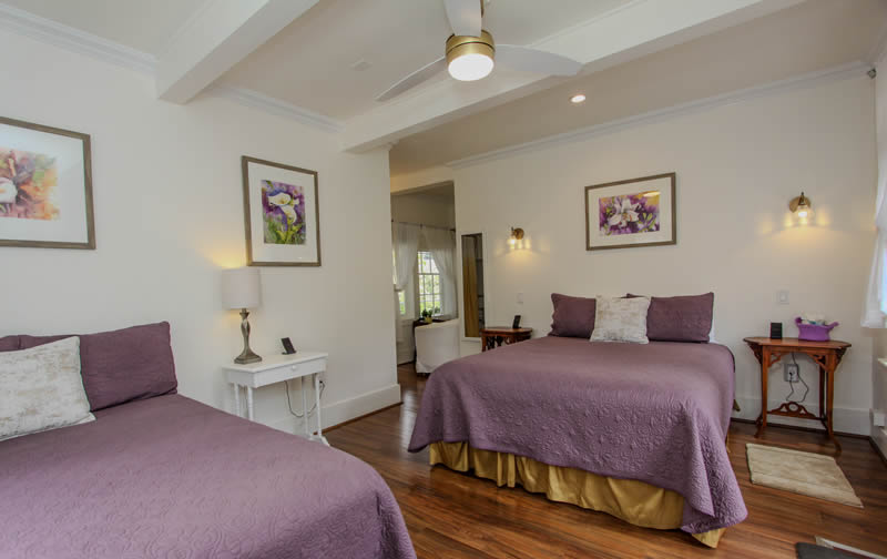 geranium room with two double beds and small sitting area